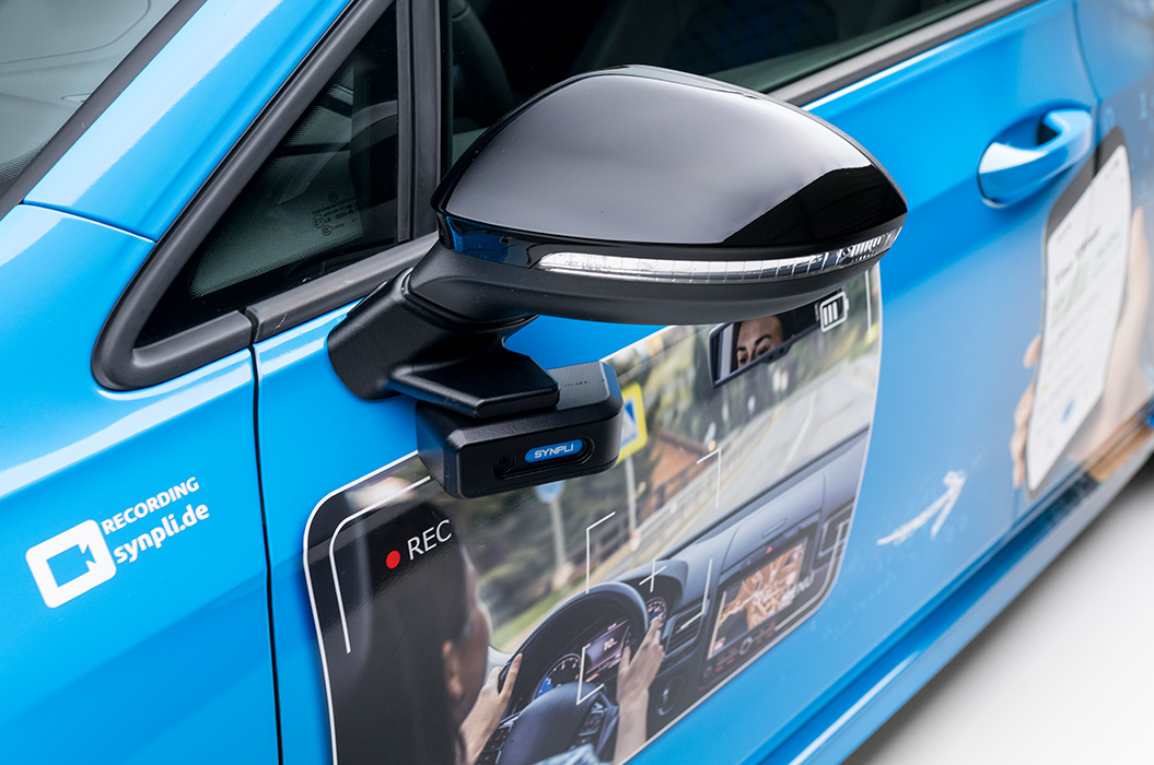 Blauer Wagen mit auffälligem Kamera Seitenspiegel und digitaler Anzeige